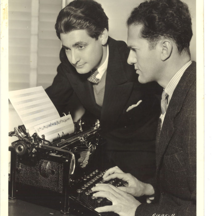 Leo Robin and Ralph Rainger, contemplatively, working with the newly invented tune typing machine